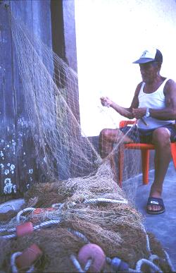 Fisherman mending his nets and hopes